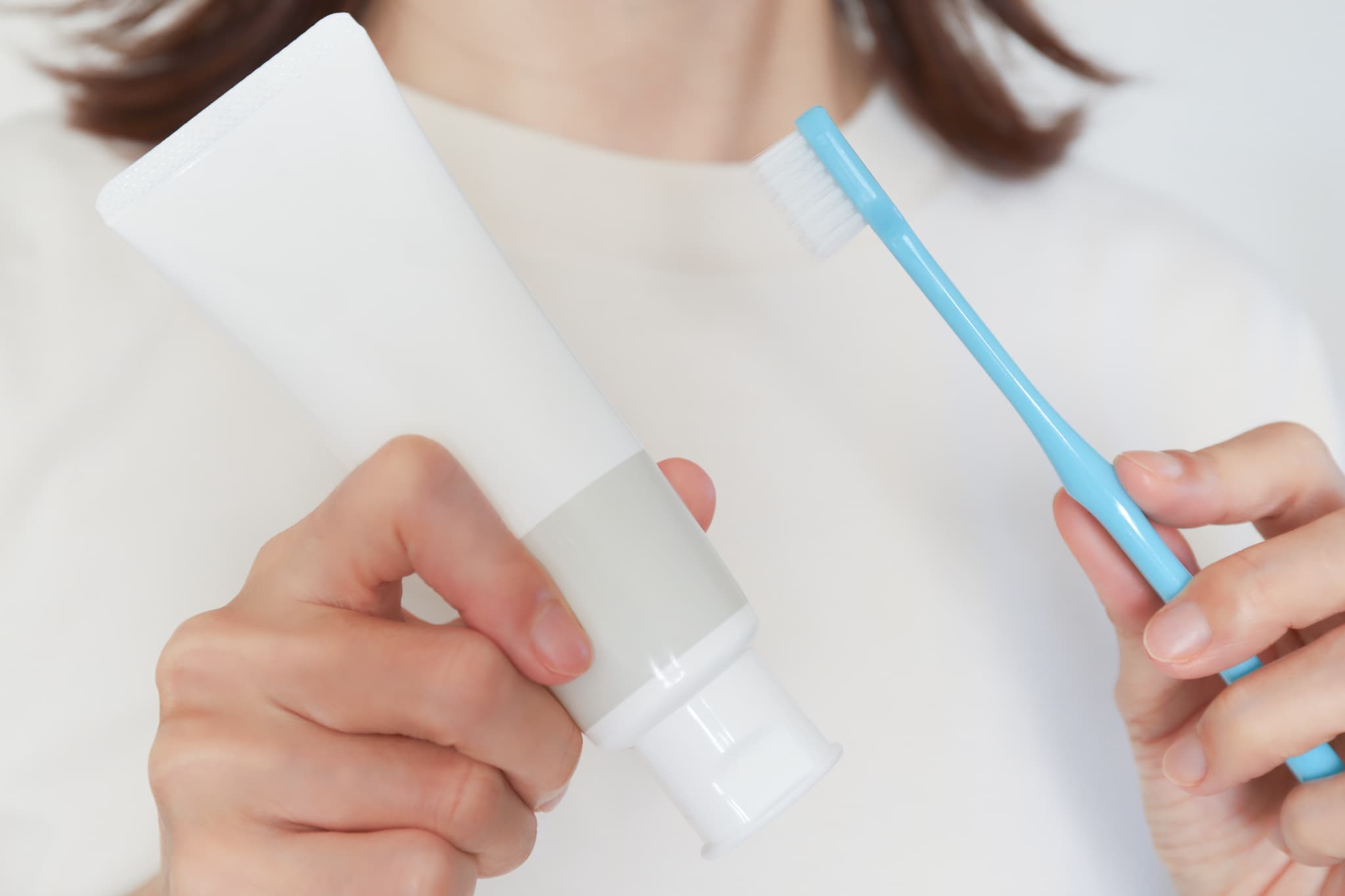 歯ブラシと歯磨き粉を持つ女性