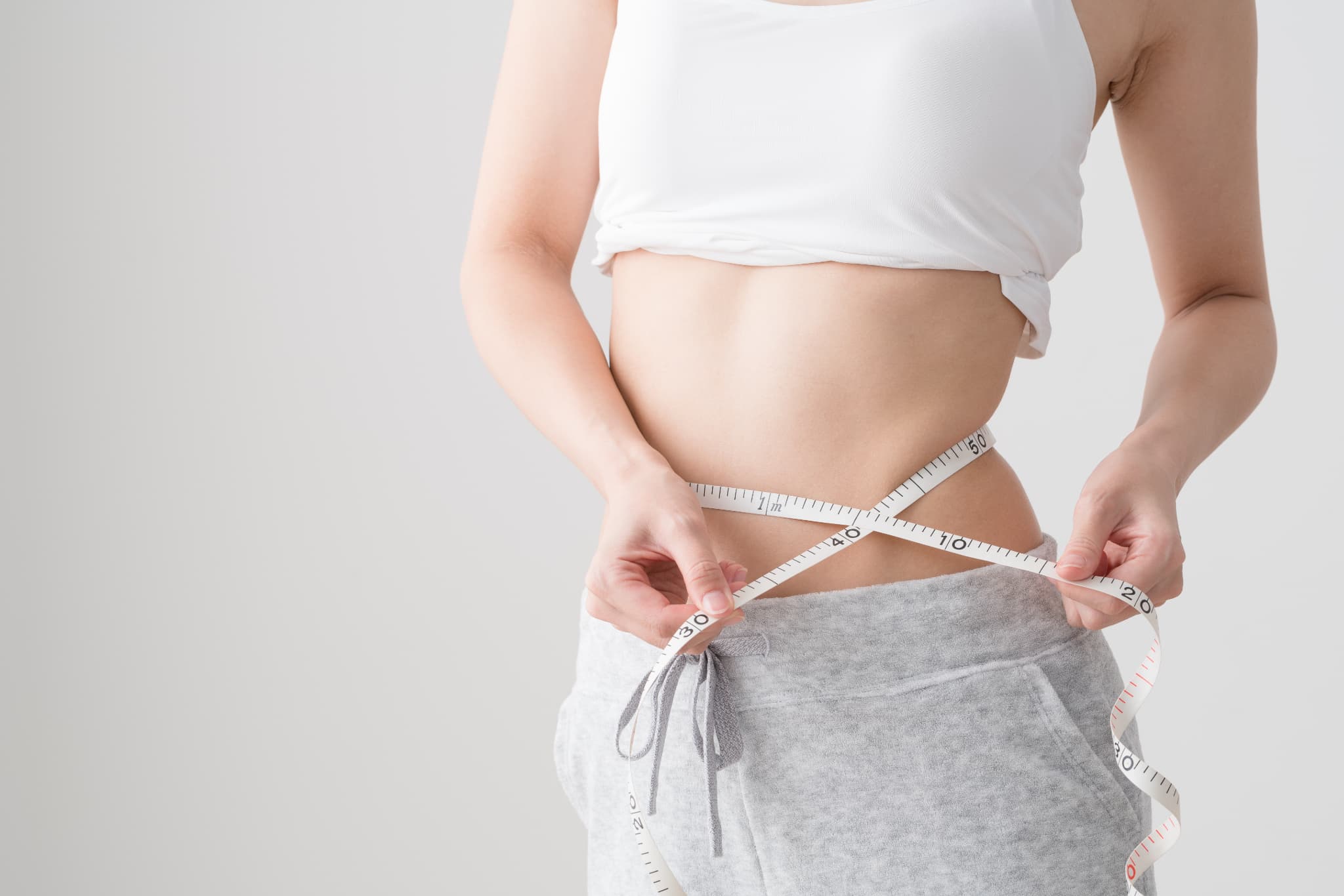 ウエストのサイズを計る女性